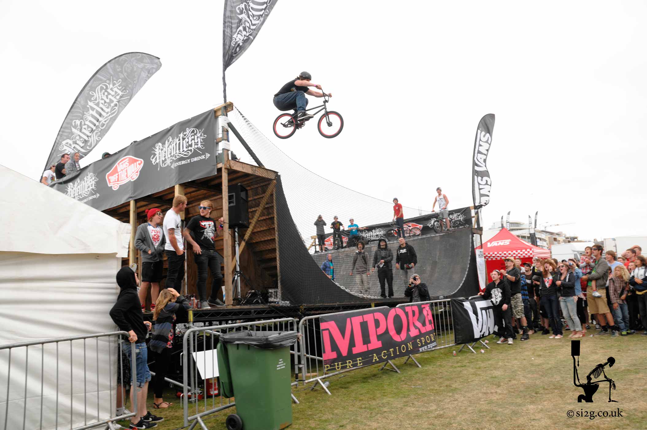 Insane BMX Transfer to Floor - Competing to win Best Trick at Newquay Boardmasters, this BMX Rider entertains the crowds with an insane transfer from the top of the ramp down to the grass.  This craziness happened unannounced and I happened to capture the photograph whilst queuing for my lunch at the burger van.  In this case the burger van was the right place a the right time.